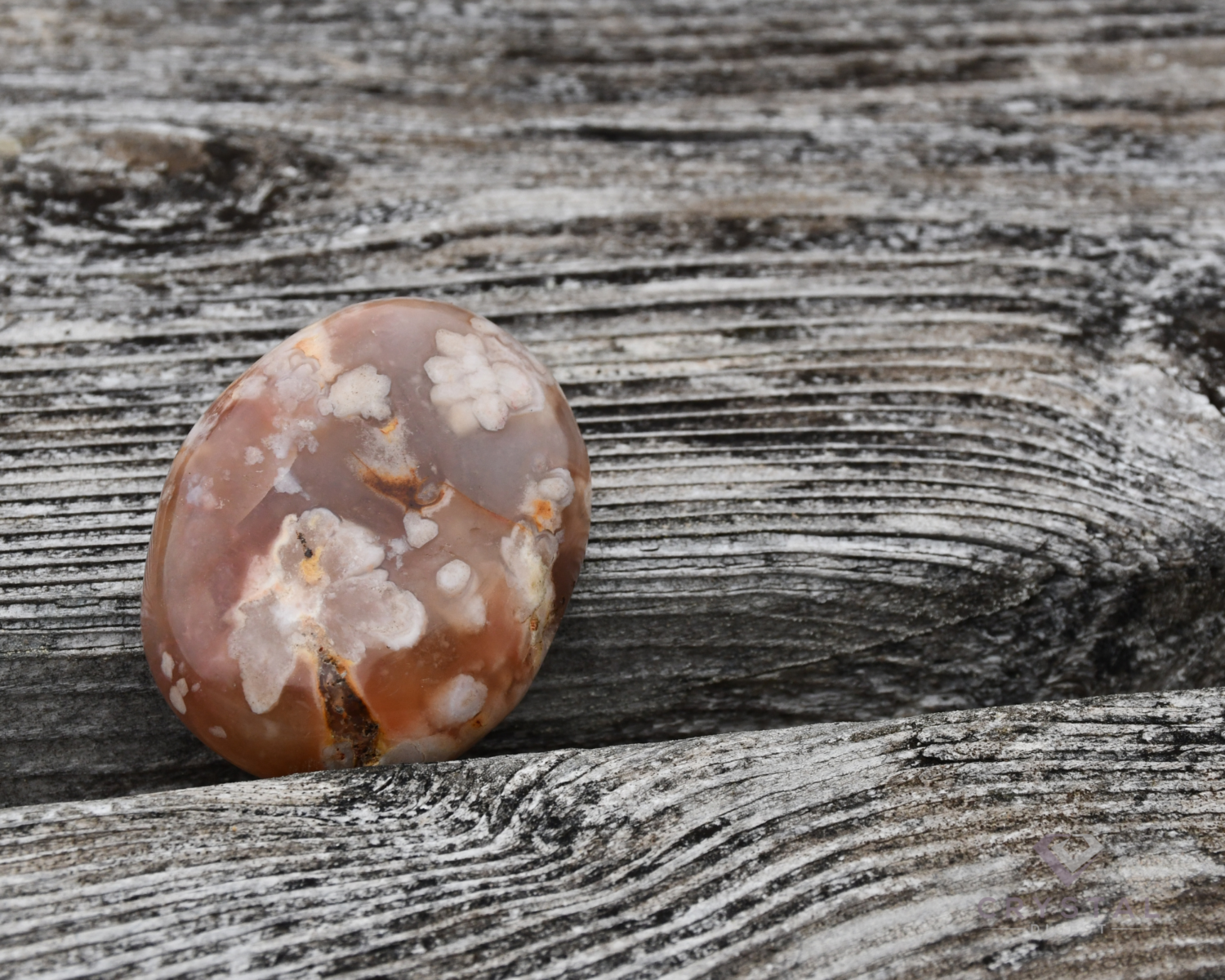 Flower agate crystal on a weathered wood table