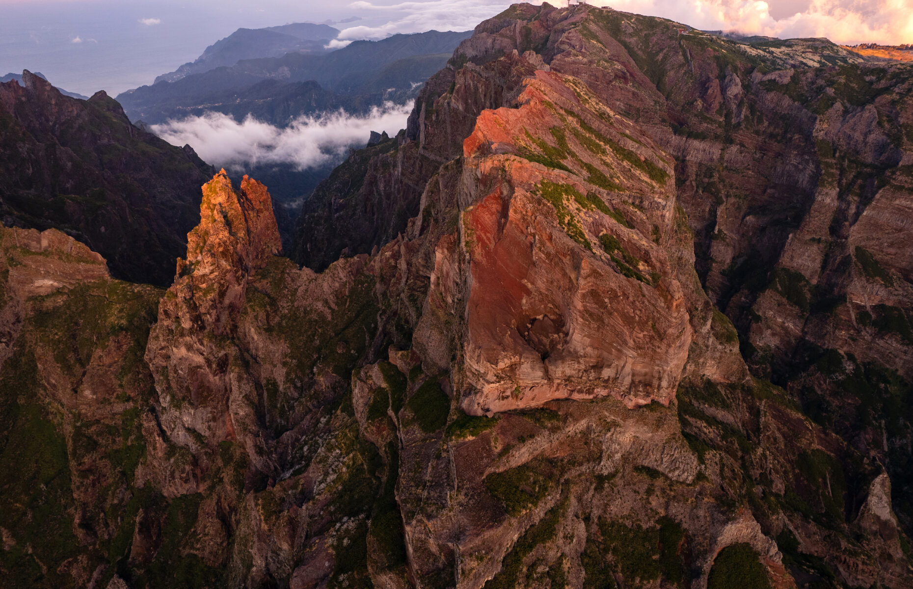 Breathtaking drone view of rocky mountains located against cloudy sky at sundown in highland of Madeira, Portugal