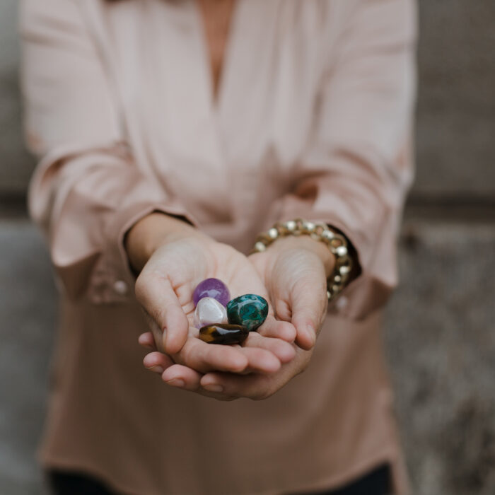 An unrecognizable woman holding colorful gemstones